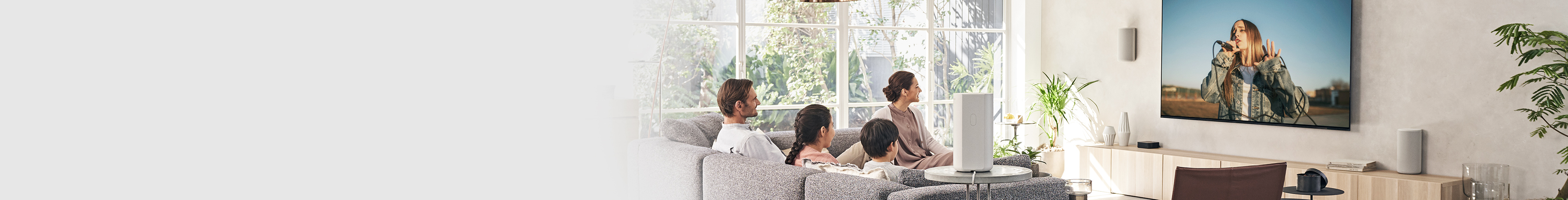 תמונה של משפחה של ארבעה אנשים נחה על הספה וצופה בטלוויזיה.