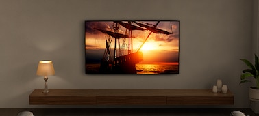 טלוויזיה תלויה על קיר המציגה תמונת סירה בשקיעה