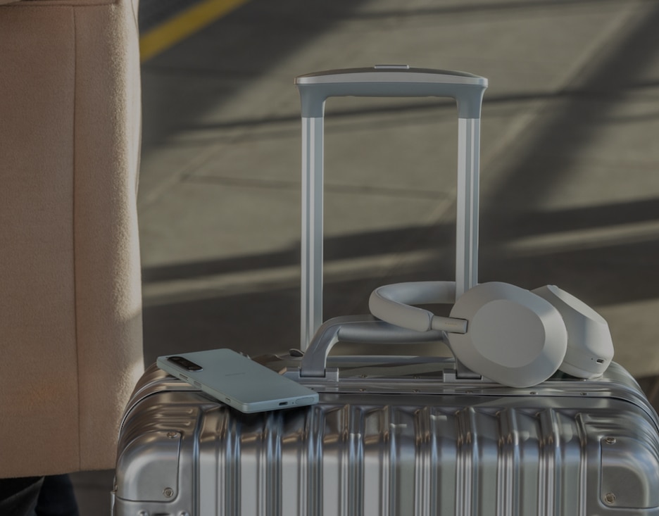 Image of a Sony Wireless Headphone and a mobile phone on a suitcase