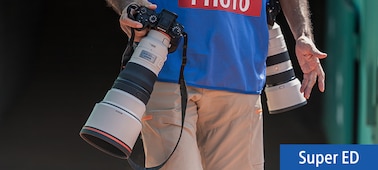 תמונת שימוש המציגה צלם הנושא שתי מצלמות עם עדשות טלפוטו