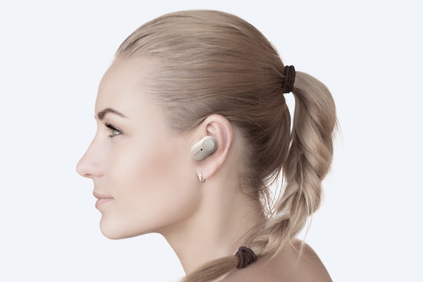 צילום של אישה שמרכיבה אוזניות WF-1000XM3 בעלות בקרות מגע הניתנות להתאמה אישית.