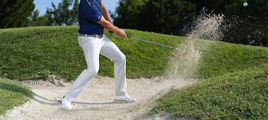 תמונה לדוגמה של שחקן גולף חובט מעל מכשול, רגעים אחרי שהמחבט פוגע בכדור