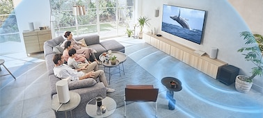 כל המשפחה יושבת על הספה וצופה בטלוויזיה עם מערכת קולנוע ביתי HT-A9 על גבי שידה מעץ, כאשר הסאב-וופר פולט גלי קול.