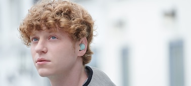 איש צעיר לובש אוזניות כפתור WF-C500 בירוק