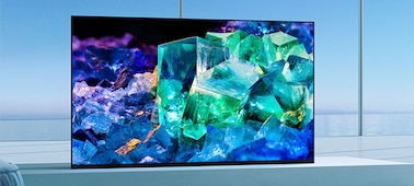 טלוויזיית BRAVIA בסלון על מעמד בסגנון מיקום קדמי לחוויית צפייה סוחפת ועשירה עם תמונה של זכוכית וקריסטלים צבעוניים על המסך