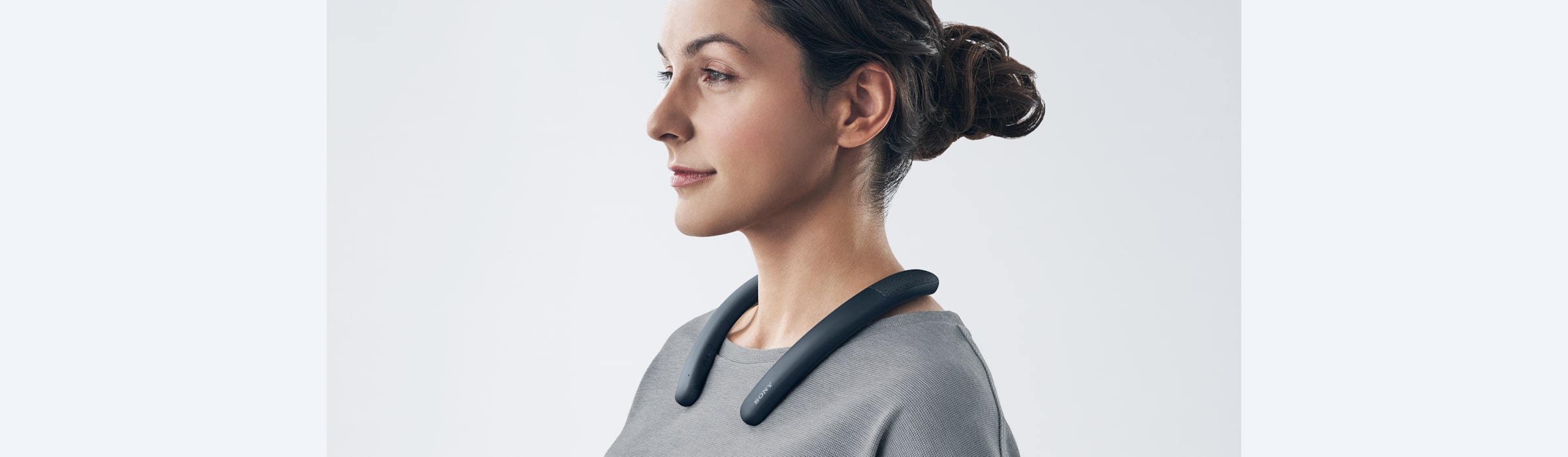 אישה מרכיבה את הרמקול האלחוטי עם רצועת הצוואר מדגם SRS-NB10 בצבע שחור