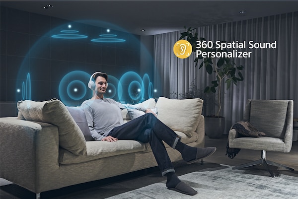 אדם יושב על ספה ומאזין לאוזניות עם המחשה של אפקט 360‎ Spatial Sound Personalizer סביב ראשו