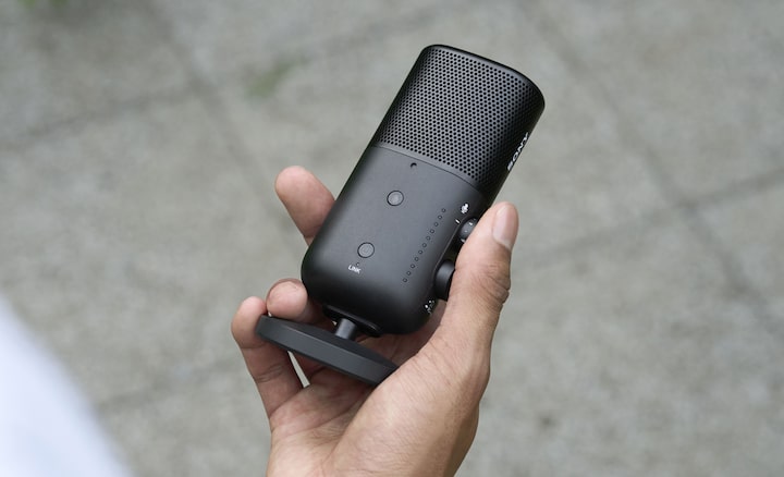 תמונת מוצר של אדם מחזיק את המיקרופון ביד אחד