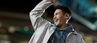 אדם רוקד באירוע באצטדיון, מרכיב אוזניות LinkBuds S ומרים את זרועו באוויר