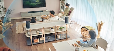 בני משפחה יושבים בחלקים שונים של הסלון וצופים בטלוויזיה, כשהם מוקפים באפקט של כיפה כחולה שמייצג צליל מרחבי 360
