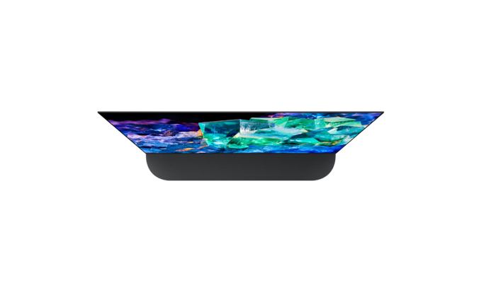 צילום עליון של BRAVIA A95K על מעמד בסגנון מיקום אחורי עם תמונה של זכוכית וקריסטלים צבעוניים על המסך