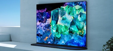 טלוויזיית BRAVIA בסלון על מעמד בסגנון מיקום אחורי ליצירת הרמוניה בחדר עם תמונה של זכוכית וקריסטלים צבעוניים על המסך