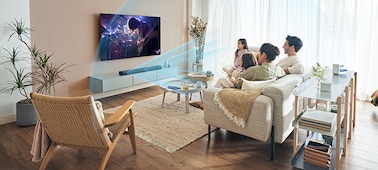 משפחה שצופה בטלוויזיה עם גלי קול כחולים שיוצאים ממקרן הקול