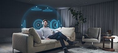 אדם יושב על ספה ומאזין לאוזניות עם המחשה של אפקט 360‎ Spatial Sound Personalizer סביב ראשו