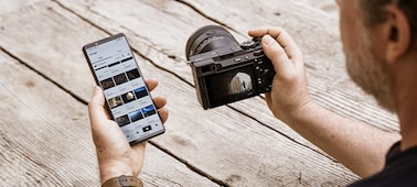תמונת שימוש המציגה משתמש שמעביר תמונות ממצלמה לטלפון חכם