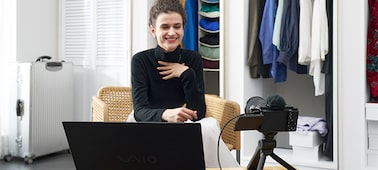 נשים מבצעות הזרמה חיה, מול מחשב נייד ומצלמה על חצובה