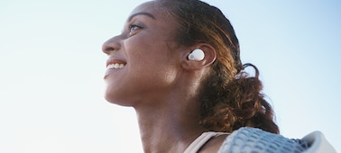תמונת תקריב של ראש וכתפיים של אישה המרכיבה אוזניות LinkBuds S לבנות בזמן הריצה