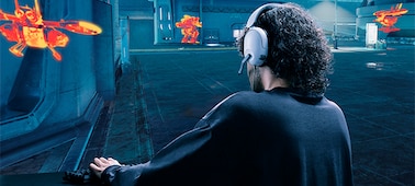 אדם המרכיב אוזניות INZONE H3 באווירת משחק עם בניינים ומטרות נסתרות המודגשות בכתום