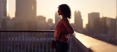 תמונת פורטרט שמציגה אישה על רקע נוף עירוני
